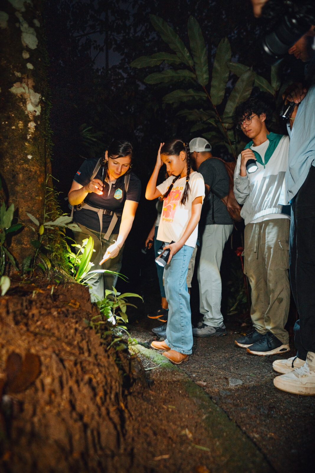 Visitor exploring rainforest on a night walk in Arenal